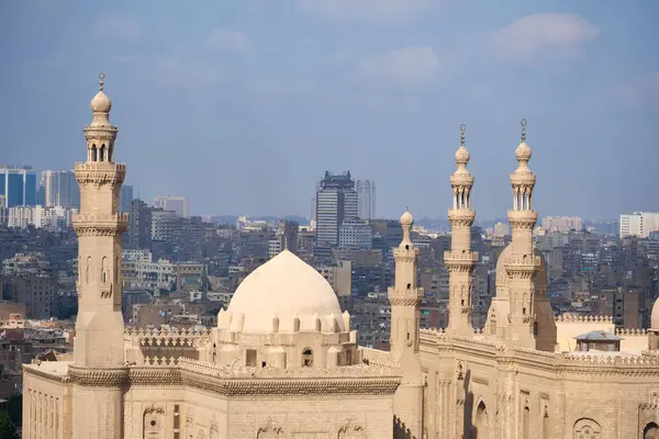 Sultan Hasan Camii 'nin kubbe ve minareleri ve Kahire Kalesi' nin arka planında görünen Kahire binaları.