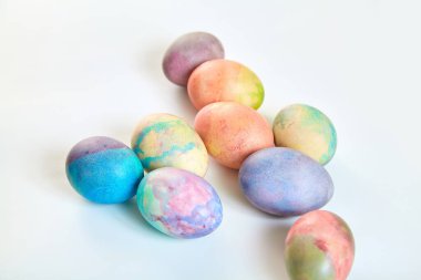 Paskalya tatiline özen göster. Farklı renklerde boyanmış birkaç tavuk yumurtası beyaz bir sırt grubunda.