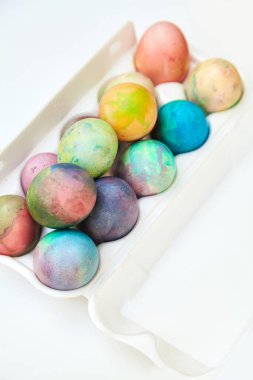Paskalya tatiline özen göster. Farklı renklerde boyanmış tavuk yumurtaları, hücreli plastik bir kapta bulunur.