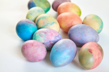 Paskalya tatiline özen göster. Farklı renklerde boyanmış birkaç tavuk yumurtası beyaz bir sırt grubunda.