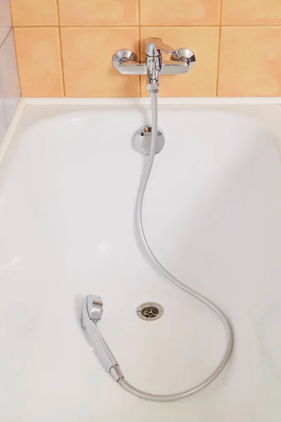 圆形淋浴器头的钢制软管放在白色拖把的底部 — 图库照片