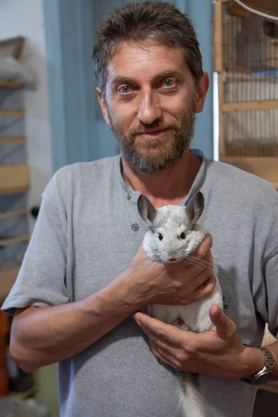 Zoologist Beard Hugs Contented White Chinchilla Cages Decorative Birds Visible — Stock Photo, Image