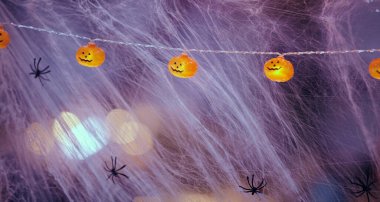 Leylak yapay ağı ve gülen balkabakları şeklinde elektrik ampulleri sarı ışıkla yanar.