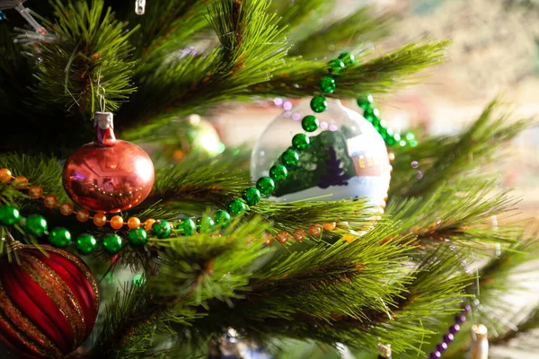 圣诞树的树枝上挂着一个绿色小球的花环 彩色玩具挂在附近B — 图库照片