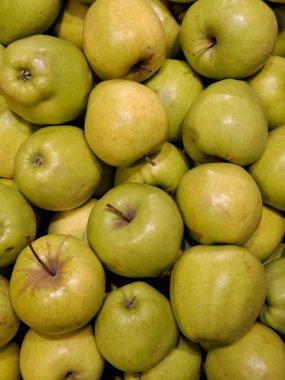 Sarı elma dokusunun arkaplan fotoğrafı. Süpermarkette taze sarı ve yeşil elmalar.