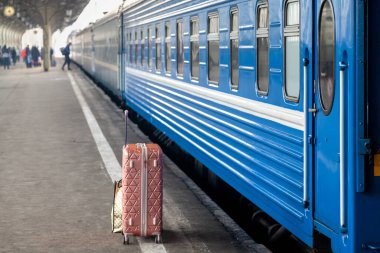Tekerlekli bavul boş bir tren istasyonunda duruyor.