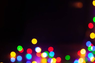 Düzenli olarak yuvarlak şekilli parlak ışıklar siyah arka planda kaotik bir şekilde düzenlenir. Çerçevenin altında soyut ışık lekeleri kümesi. Bir yazıt için üste boş siyah alan