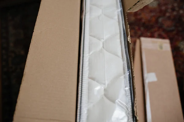 从生物泡沫有机家具制成的回收纸箱纸板包装中取出新床垫 — 图库照片