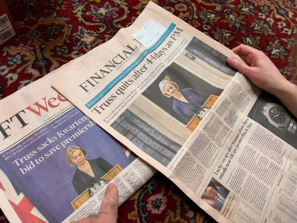 英格兰 10月20日 金融时报 在威斯敏斯特首页上刊登了一则女性在客厅地板上阅读宣布利兹 特劳斯总理辞职的消息 — 图库照片