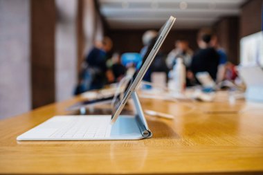 Paris, Fransa - 28 Ekim 2022: Yeni Apple Bilgisayarları iPad tabletinin yan görüş kahraman objesi Sihirli Klavye Foliosu üzerinde - yeni donanım için arka plan alışverişinde müşteri siluetleri