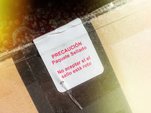 用西班牙文翻译的纸板上的信息闪烁其词 如果打开封条 请不要接受密封包装 — 图库照片