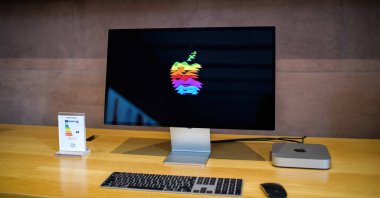 Paris, Fransa - 28 Ekim 2022: M2 M3 işlemcili yeni Apple Bilgisayarları MacMini bilgisayar çalışma istasyonu Apple renkli logoyu gösteren 5k Retina ekranına bağlı