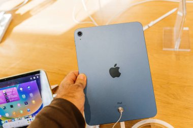 Paris, Fransa - 28 Ekim 2022: Yeni Apple Bilgisayar iPad 'inin yakın çekimi mağazadaki sarı renkli 10. nesil - arkasında büyük logotype amblemi olan arka kameraya bakıyor