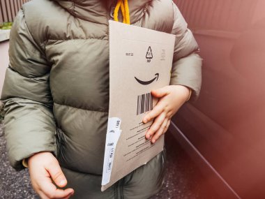 Lüksemburg - 8 Kasım 2022: Amazon Prime karton karton kutusunu elinde tutan erkek çocuk - çevrimiçi perakendeciden hızlı teslimat