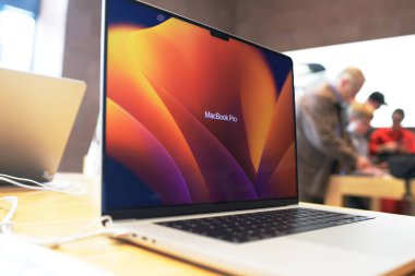 Paris, Fransa - 28 Ekim 2022: Dünyaca ünlü MacBook Pro dizüstü bilgisayarı ve yeni Apple Silikon işlemcisi - arka planda alışveriş yapan müşteriler