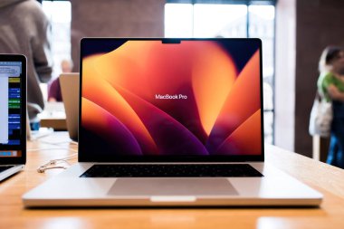 Paris, Fransa - 28 Ekim 2022: Dünyaca ünlü MacBook Pro 'nun arka planda alışveriş yapan müşterileri ile birlikte yeni güçlü Apple Bilgisayarlarının ön görüntüsü