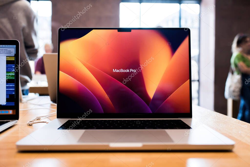 Paris, France - Oct 28, 2022: Front view of new powerful Apple Computers laptop the world renowned MacBook Pro 16 inch with new Apple Silicon processor - customers shopping in background