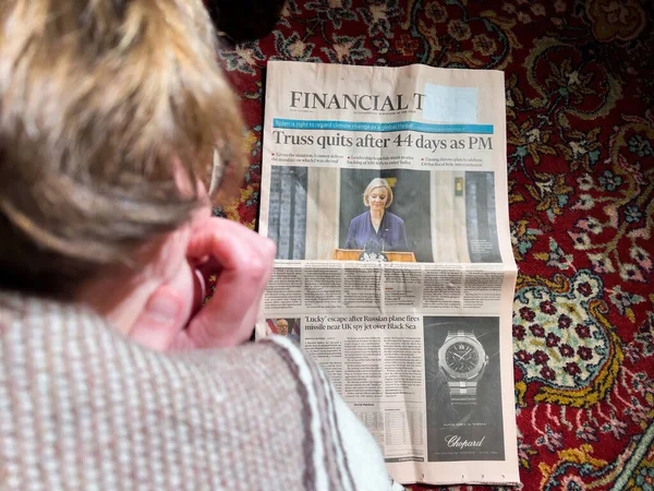 英国伦敦 Feb 2022年2月2日 最新一期 金融时报 女性在客厅丝毯地板上看书的头像 头条是在担任英国首相44天后辞职 — 图库照片