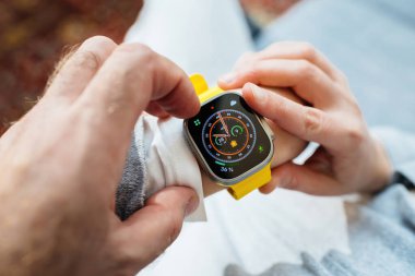 Londra, Birleşik Krallık - Sep 28, 2022: POV 'lu kadın yeni Apple Watch serisi Ultra erkeğinin elini tutuyor ve yeni Wayfinder yüzünü gece moduyla donatıyor - dayanıklılık gibi uç aktiviteler için tasarlandı