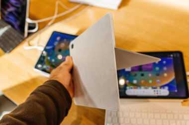 Paris, France - Oct 28, 2022: Personal perspective customer hand holding side view of Magic Keyboard Folio for iPad 10th generation