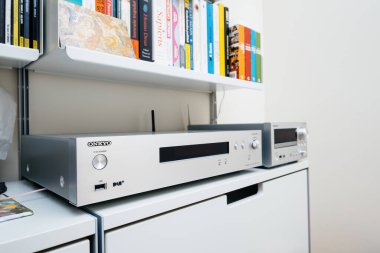 Paris, France - Dec 13, 2022: POV male hand pointing to Chromecast built-in, certified sign on new Onkyo NS-6170 network audio player with DSD Hi-Res Audio and DSD DAB WIFI device carpet rug silk