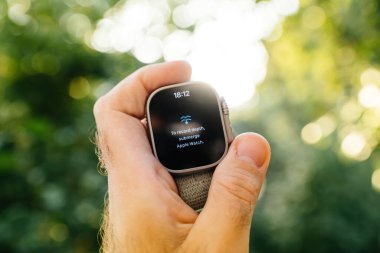 London, United Kingdom - Sept 28, 2022: Male hand holding new Apple Watch Ultra Smartwatch against defocused bokeh background with Dive app and message to record dept submerge apple watch