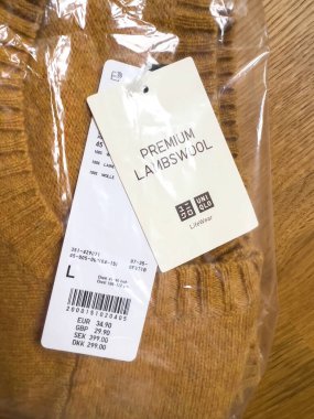 Paris, France - Nov 11, 2022: Close-up macro shot of UNIQLO premium lambswool sweater with the price of 34,90 eur of 29,90 GBP