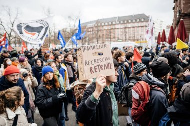 Strasbourg, France - Jan 19, 2023: Worker search for job placard in male hand - Large crowd at protest against the French governments planned pension reform to push the retirement age from 62 to 64