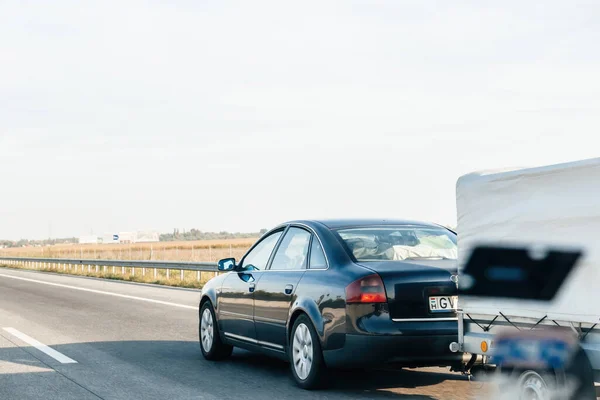 stock image Hungary - Sep 20, 2014: Side view of driving fast luxury black Audi with trailer on Hungarian highway