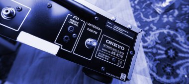 Paris, France - Dec 13, 2022: POV male hand pointing to Chromecast built-in, certified sign on new Onkyo NS-6170 network audio player with DSD Hi-Res Audio and DSD DAB WIFI device carpet rug silk