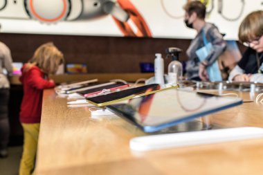Paris, France - Oct 28, 2022: Hero object side view of new Apple Computers iPad 10th generation in Pink color in store - youg childrens customers shopping in background playing on he devices