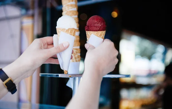 Woman taking 2 whipped ice cream cones from the ice cream van - declious bio organic sweet summer food