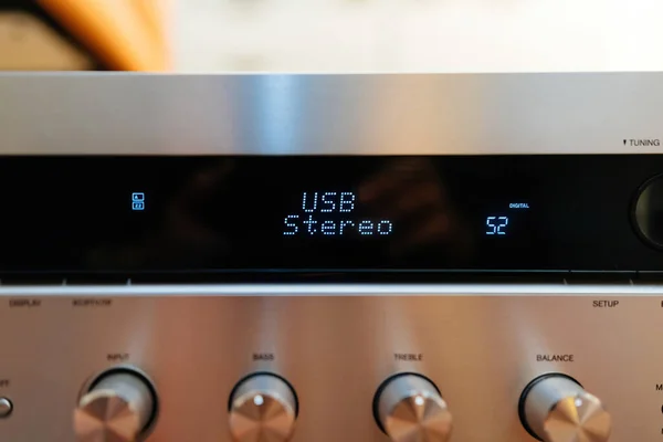 USB stereo text on the LCD display aluminum facade figh-end stereo audio hi-fi receiver with multiple knobs - close-up tilt-shift lens used