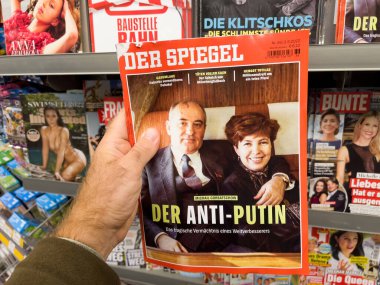 Frankfurt, Germany - Sep 3, 2022: POV male hand buying latest newspaper magazine Der Spiegel with Mikhail Sergeyevich Gorbachev and his wife Raisa and title - The Anti-Putins