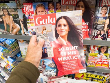 Frankfurt, Germany - Sep 3, 2022: POV male hand buying latest newspaper magazine Gala magazine with Meghan Markle feature article and title 