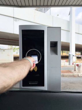 POV erkek sürücü el otopark çıkışının biletini arabadan parkmetreye yerleştiriyor.