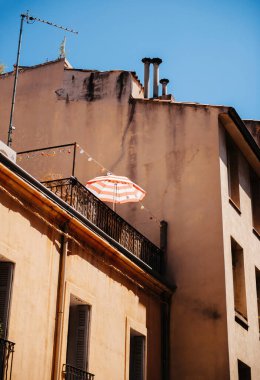 Aix En Provence şehrinin balkonundaki terasta güneş kremi şemsiyesi. Fransa 'nın güneyindeki güneş gayrimenkullerinde dinlenen sıcak bir gün.