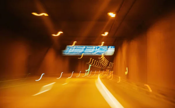 Distorted View Lights Signs Urban Tunnel Illuminated Yellow Hue Creating — Stock Photo, Image