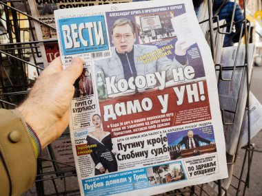 Paris, Fransa - 20 Mar 2023: Sırbistan Cumhurbaşkanı Aleksandar Vuciç ile ilgili Vesti gazetesi basın büfesinde erkek el alımı, Vladimir Putin ile aynı sayfada