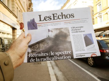 Paris, Fransa - 20 Mart 2023: Radikalleşme hayaleti - emeklilik - Les Echos gazetesinin başlığı erkekler tarafından okunuyor