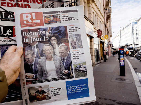 Paris, France - Mar 20, 2023: POV male hand buy press reading Le republicain Lorrain featuring Elisabeth Borne and votes pension reform wanted by the French government which would raise the retirement