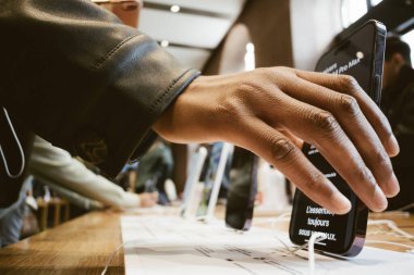 Paris, Fransa - 22 Ekim 2022: Yetenekli bir adam yeni iPhone 15 'ini Apple Bilgisayar' ın içindeki bir şarj limanına yerleştiriyor ve yeni teknolojinin güzelliğini ustalıkla gösteriyor.
