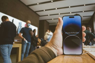 Paris, Fransa - 22 Eylül 2022: POV kişisel perspektifi Apple yeni akıllı telefon iPhone 14 Pro ve iPhone 14 Pro - arka planda büyük bir kalabalıkla mağazada bekleyen müşteri