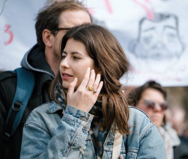 Strasborg, Fransa - 29 Mart 2023: Strasbourg 'da düzenlenen bir protestoda saç düzenleyen güzel Fransız kadın, emekli aylığı yaşının artmasıyla ilgili haftalarca süren protesto ve grev eylemleri yaşadı.