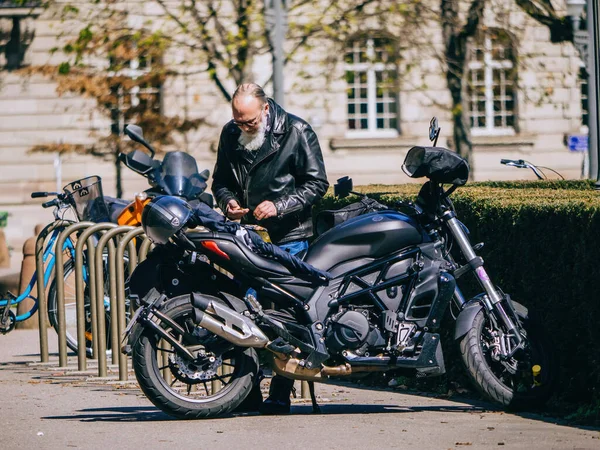 2023年3月29日 法国斯特拉斯堡 一位身穿皮夹克 头戴运动头盔的老人将他的意大利贝内利摩托车停在一座城市里 — 图库照片