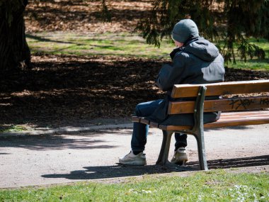 Arka manzara kıdemli adam bir parkta uzun bir bankta dinleniyor, rahatça otururken manzaranın tadını çıkarıyor..