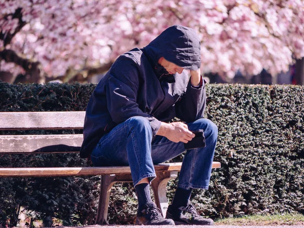 Man Sits Alone Park Bench Overwhelmed Sadness Magnolia Blooms Spring — Stock Photo, Image