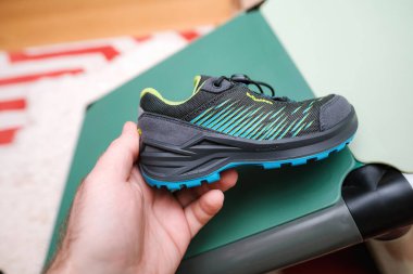 Frankfurt, Almanya - 12 Mart 2023 Orta kesim yürüyüş botları çeviklikle dolu - Lowa modern, arka planda yeşil Gore-Tex tasarımı, soğuk kış günleri için mükemmel