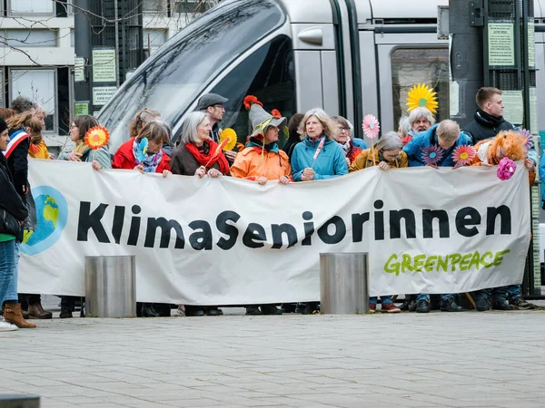 stock image Strasbourg, France - Mar 29, 2023: A group of determined Swiss seniors peacefully protest in front of the European Court for Human Rights, holding placards as they demand action on climate change from