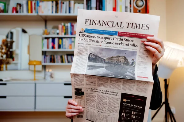 2023年3月20日 法国巴黎 金融时报 爆料瑞银历史性地收购竞争对手瑞士信贷集团 Credit Suisse Group 的消息 女性与维索606在自己的客厅里阅读媒体 — 图库照片